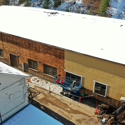 Removal of asbestos siding from the machine shop in preparation for demolition. The space will be used for future ore processing facilities to be constructed in the coming months. 